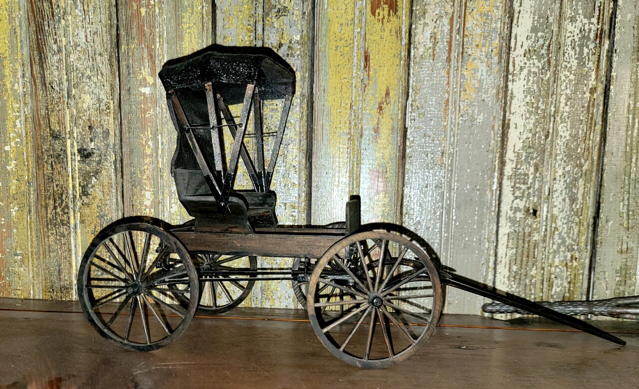 Scale model of horse drawn buggy.