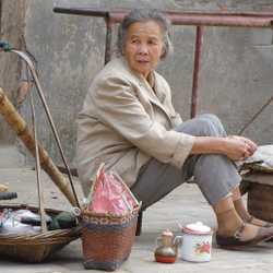 This lady sells hot rice with various condiments along side road.